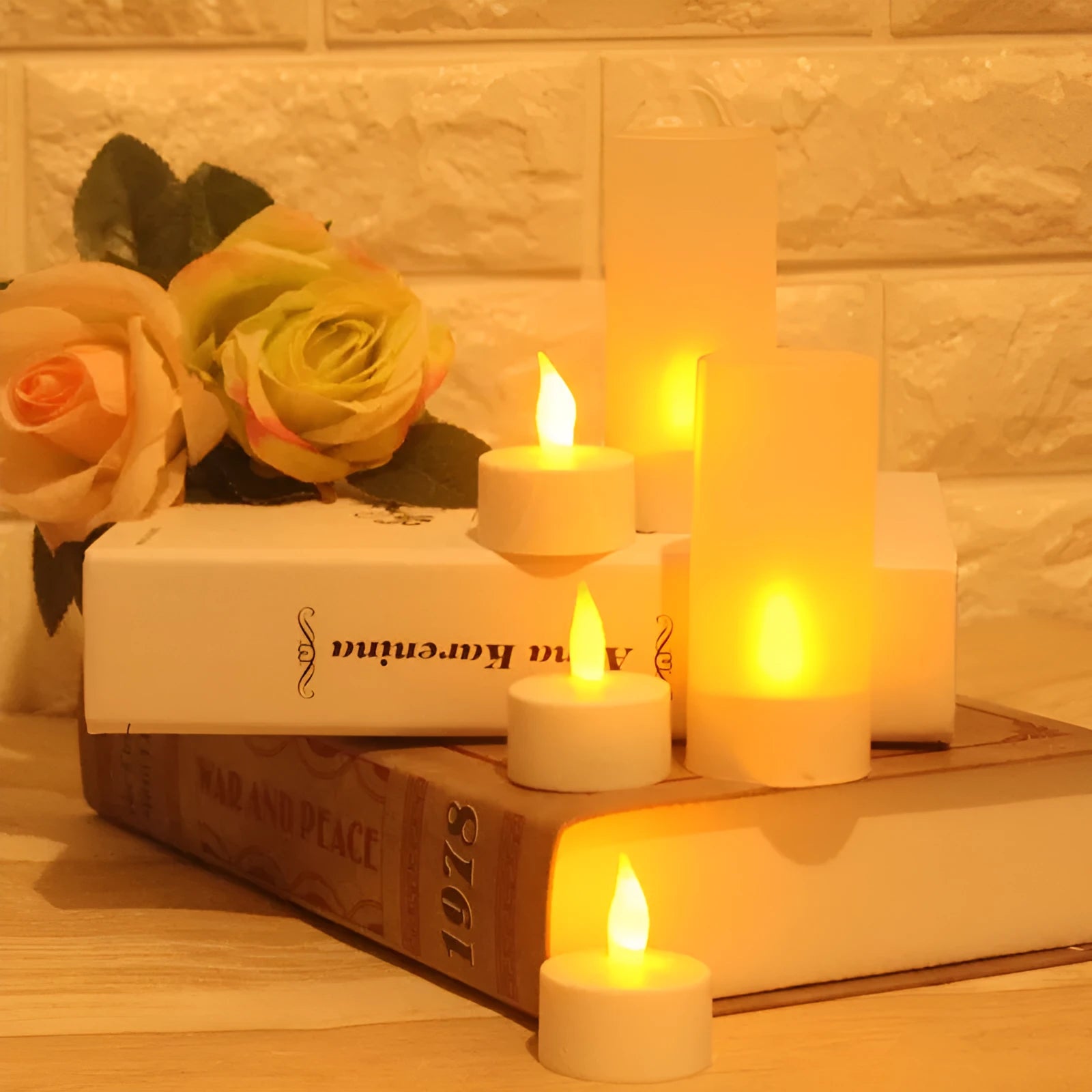 White plastic rechargeable LED candle lamp with yellow glowing flame on a table.