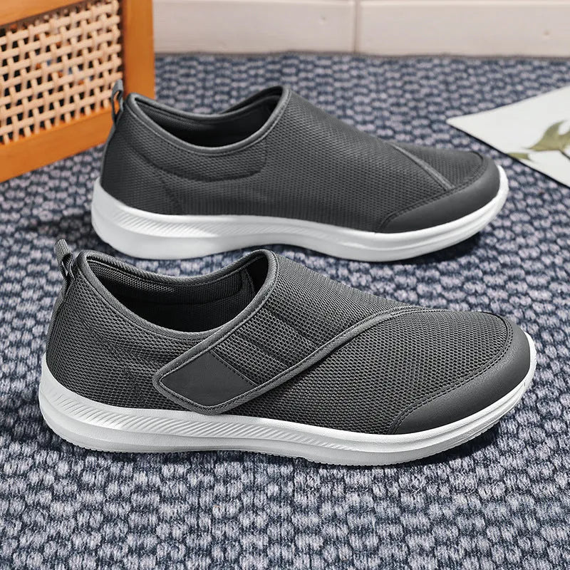 A pair of casual walking shoes with a mesh upper and Velcro strap closure, shown in one of four available colours.