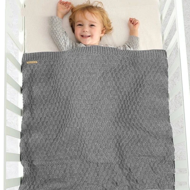 Solid colour infant blanket in light green, lying flat to show its 70 by 90 centimetre rectangular shape.